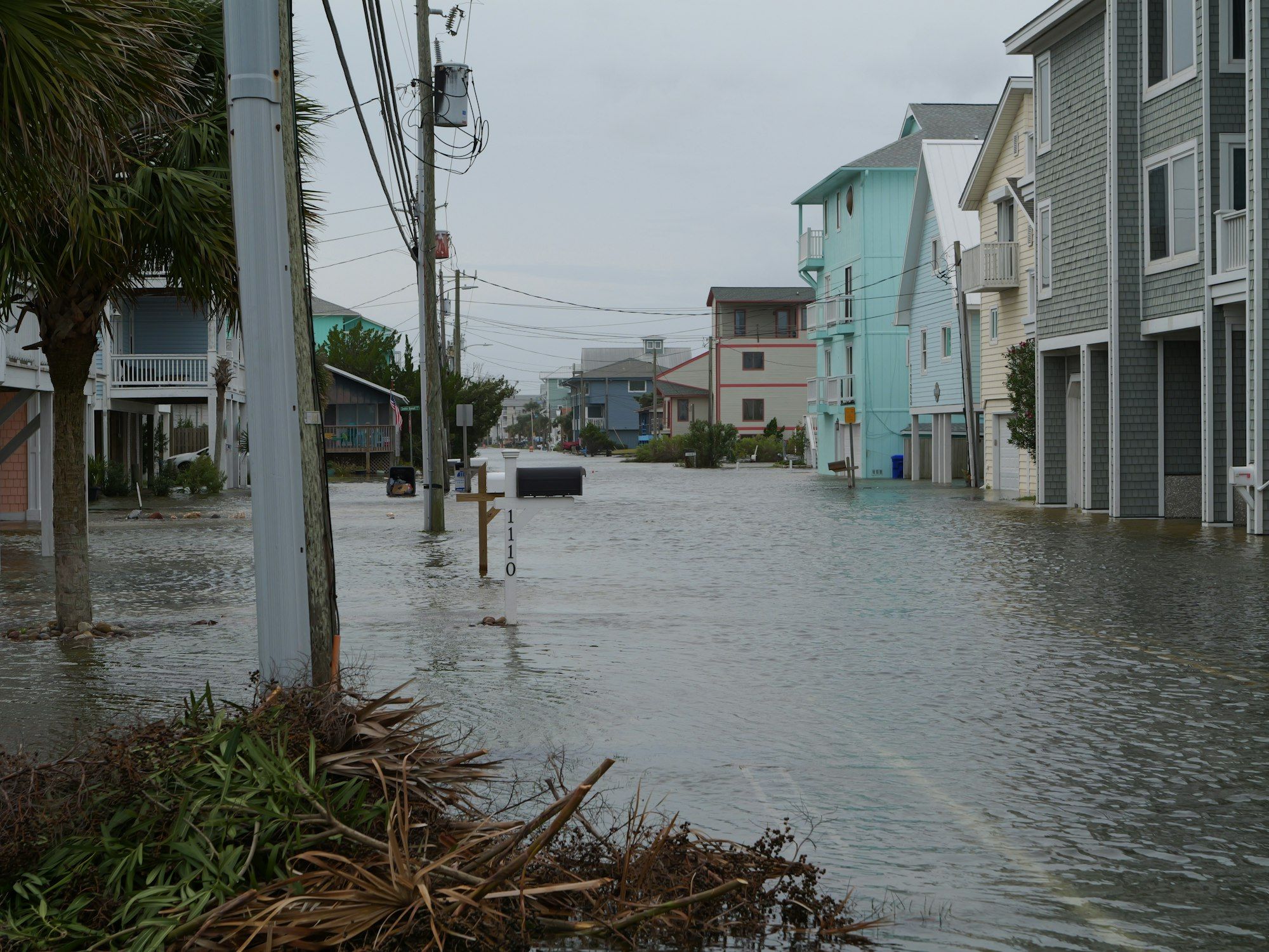 Street flooded with water and storm debris in Carolina Beach, NC